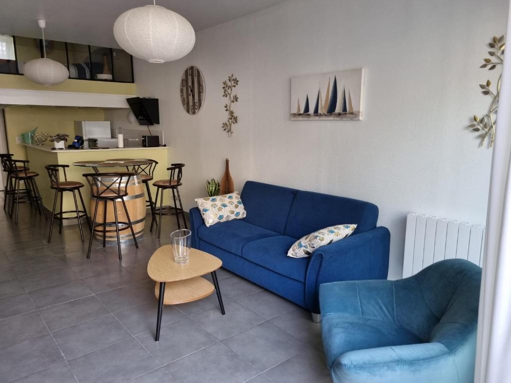 a living room with a blue couch and a table at L’EFFERVESCENT in Reims