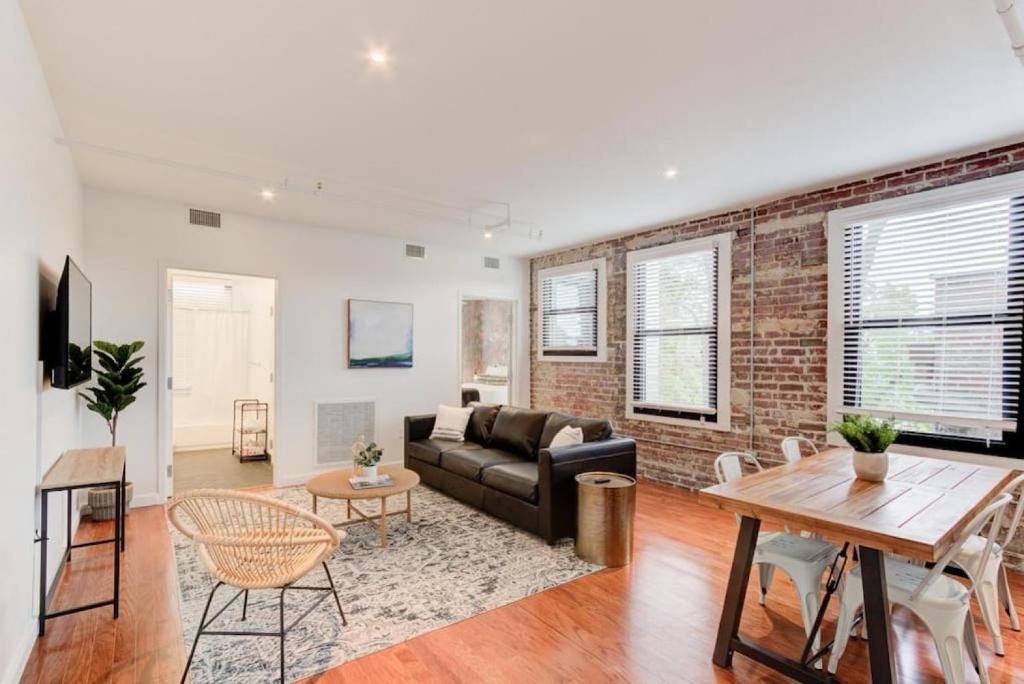 a living room with a couch and a brick wall at Modern Apartment in Historic Shell in Memphis