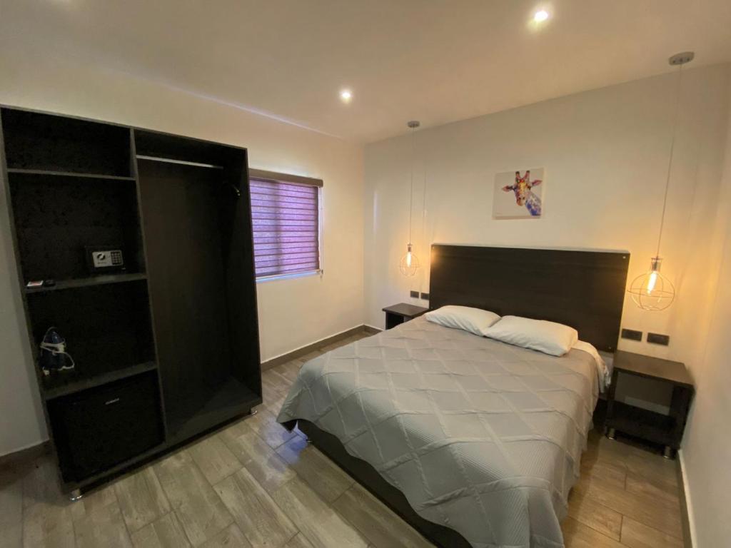 a bedroom with a large bed and a black cabinet at Quinta del sol in Chihuahua
