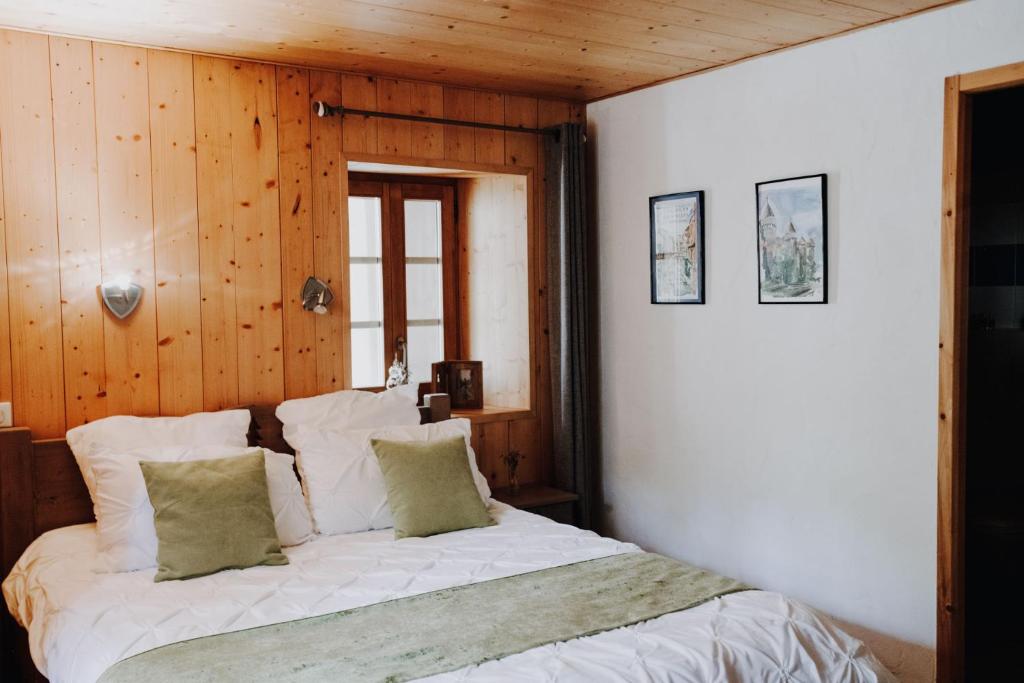 a bedroom with a white bed with wooden walls at Kern in Seytroux