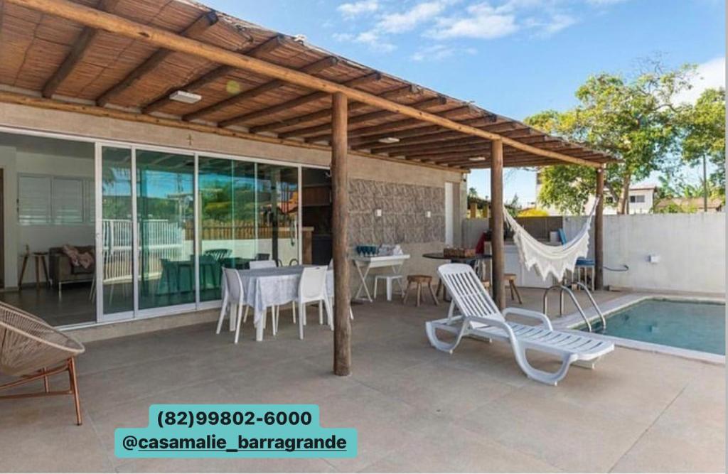 un patio con mesa, sillas y piscina en Casa Malie - Barra Grande, en Vitória de Santo Antão