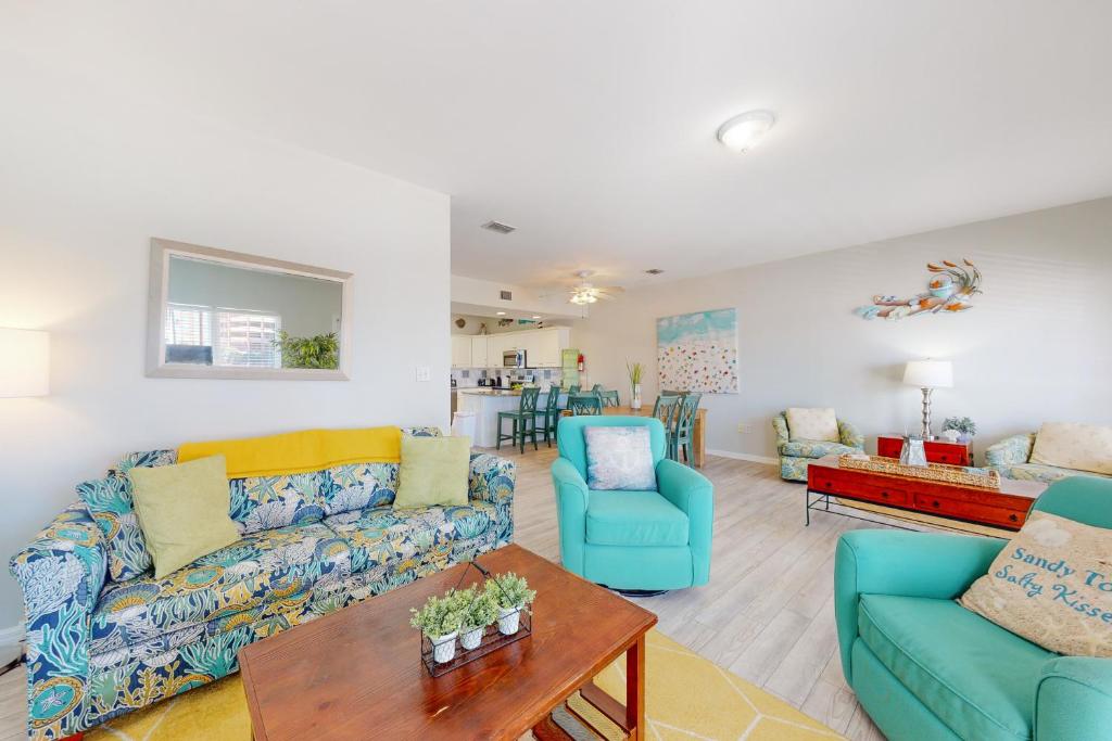 una sala de estar con sofás azules y una mesa. en Sun & Sea, en Gulf Shores