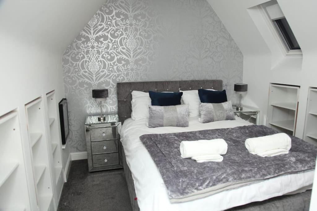 a bedroom with a large bed with two pillows on it at Luxury 4 bed house in Swindon in Swindon