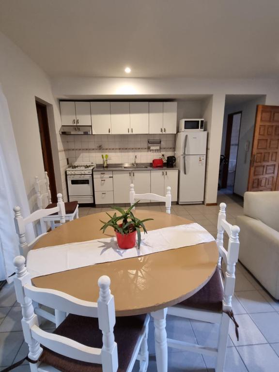 uma cozinha e sala de estar com mesa e cadeiras em Departamento en complejo residencial em Mendoza