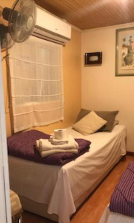 1 dormitorio con 1 cama con toallas en Habitación las Condes Familiar, en Santiago