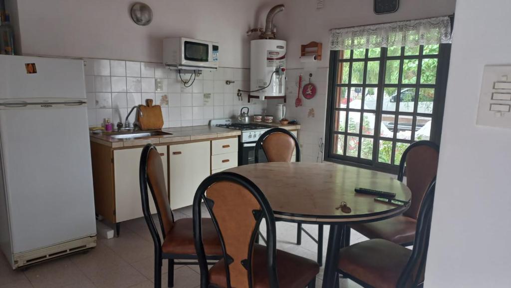 uma cozinha com uma mesa e cadeiras e um frigorífico em casa de mar em Las Grutas