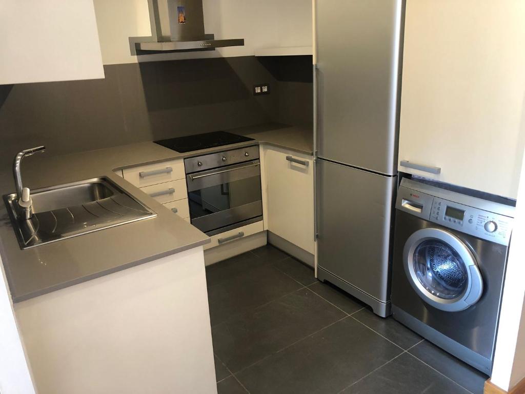 a kitchen with a stainless steel refrigerator and a washing machine at Barcelona Style Beach Apartment in Barcelona