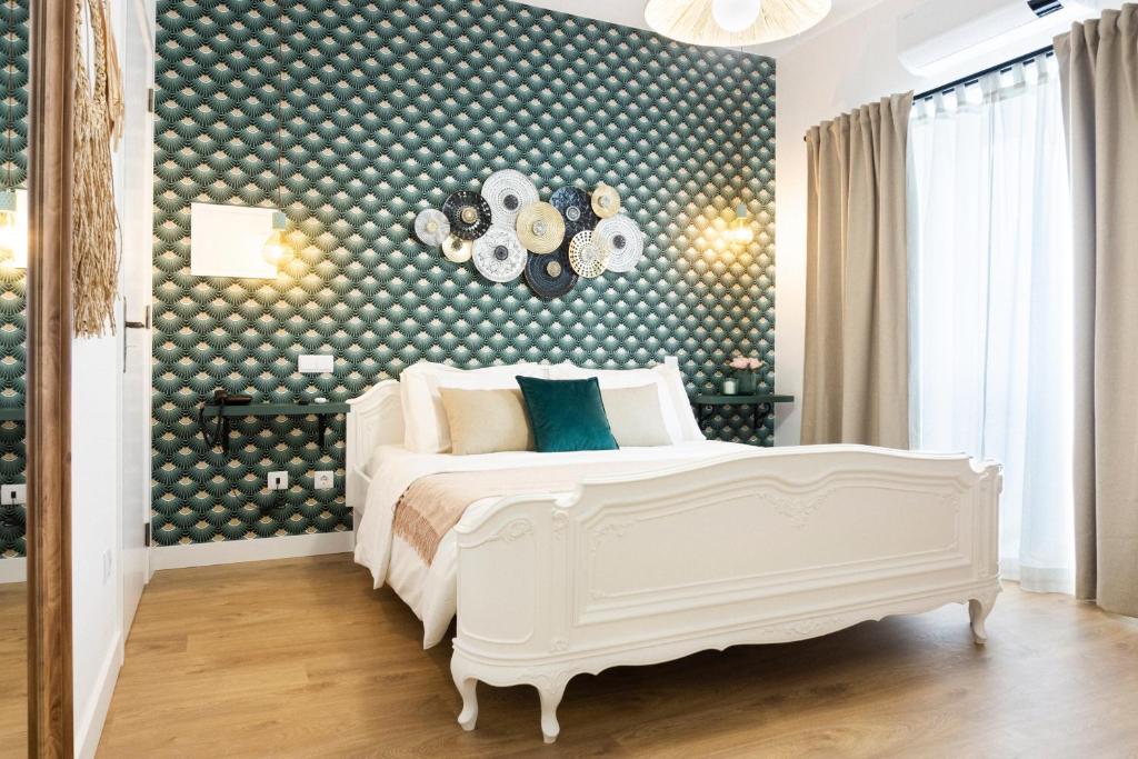 Lugar do Ourives Boutique Hotel في Senhora das Febres: غرفة نوم بسرير ابيض وجدار به نقاط بولكا