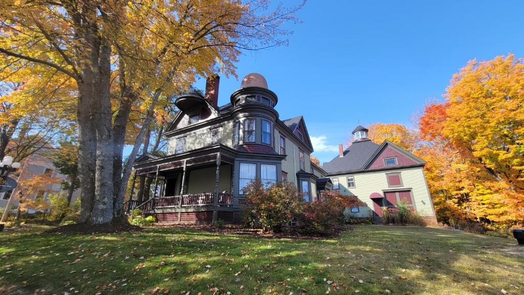 a large house on a lawn in the fall at The Elizabeth Inn and Restaurant in Bethel