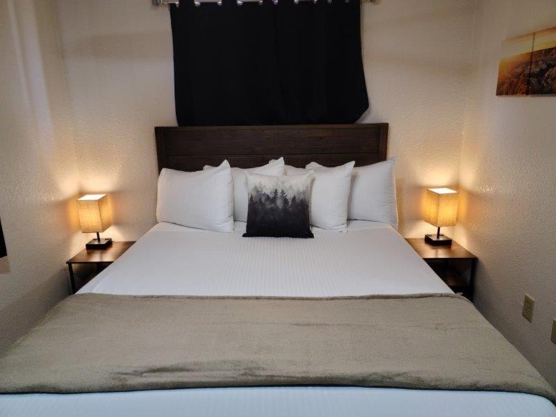 a bedroom with a large bed with two lamps at 070B Cozy Studio with Kitchen nr South Rim Sleeps 4 in Valle