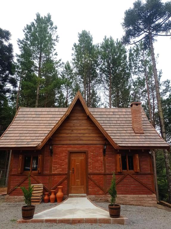 a log cabin with a wooden door in the woods at Casa Medieval in Gramado