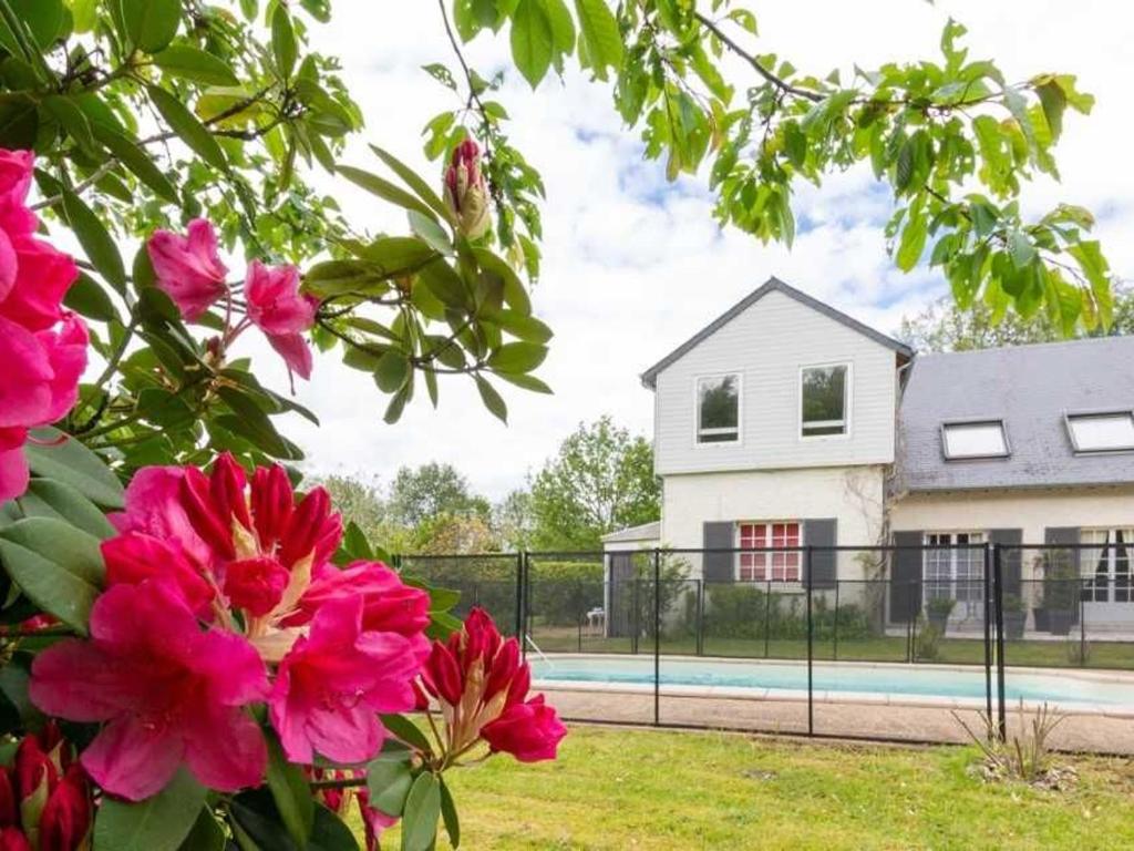 ein Haus mit einem Zaun und rosa Blumen in der Unterkunft Gîte Dureil, 2 pièces, 4 personnes - FR-1-410-331 in Dureil