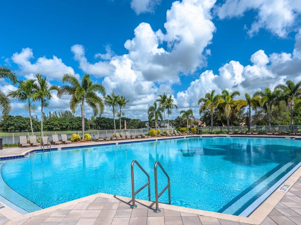 una piscina en un complejo con palmeras en Gorgeous Rooms in Miramar Prestigious State Home - Min 31 Days Rental, en Miramar