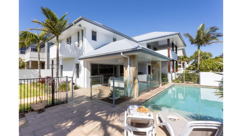 a villa with a swimming pool and a house at On Northpoint at Salt in Kingscliff