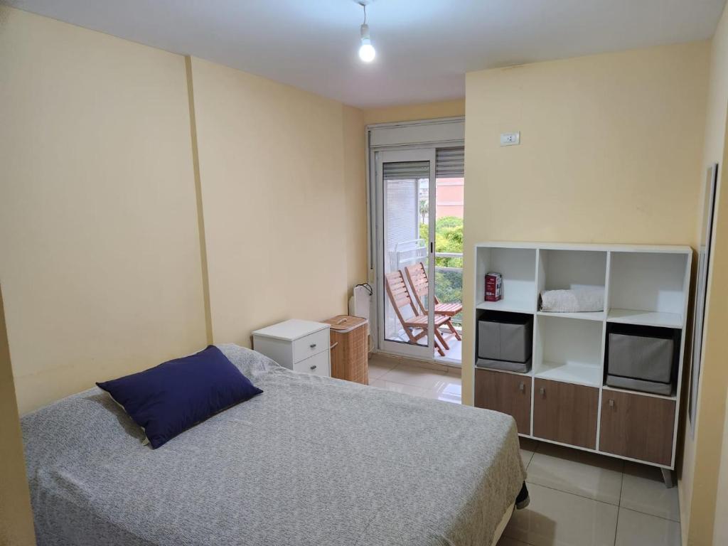 1 dormitorio con 1 cama y TV en departamento temporal La Cañada en Córdoba