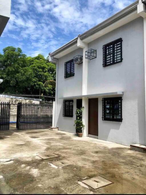 a white house with black windows and a fence at Sebastian’s Crib F in Dasmariñas