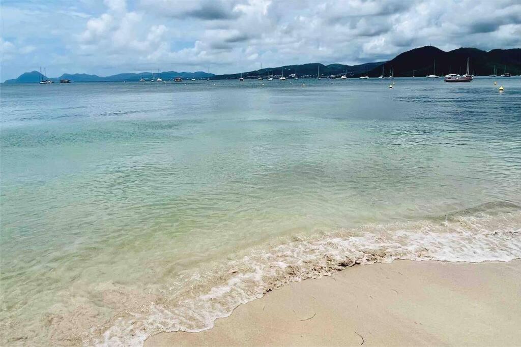 um corpo de água com uma praia de areia e o oceano em Studio La «KAZ’ À COCO» Anse Caritan em Sainte-Anne