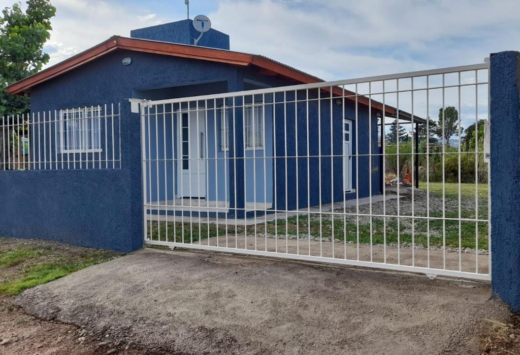 un edificio azul con una valla delante en Casa Villa Zorzal en Villa Larca