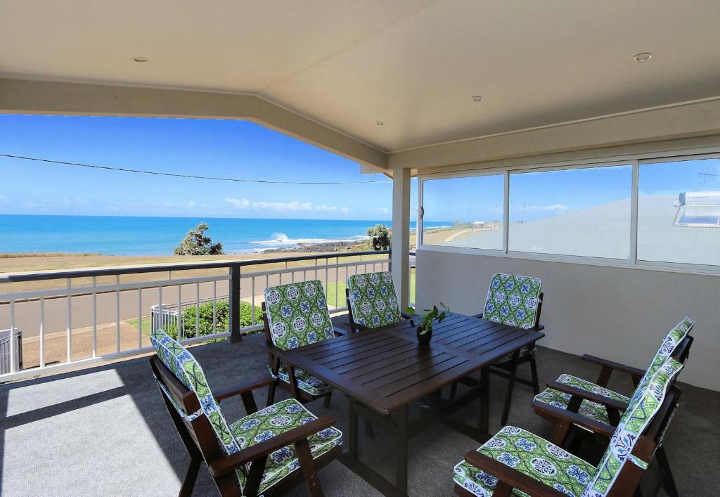 una mesa y sillas en un balcón con vistas al océano en 129 Sea Esplanade Burnett Heads, en Burnett Heads
