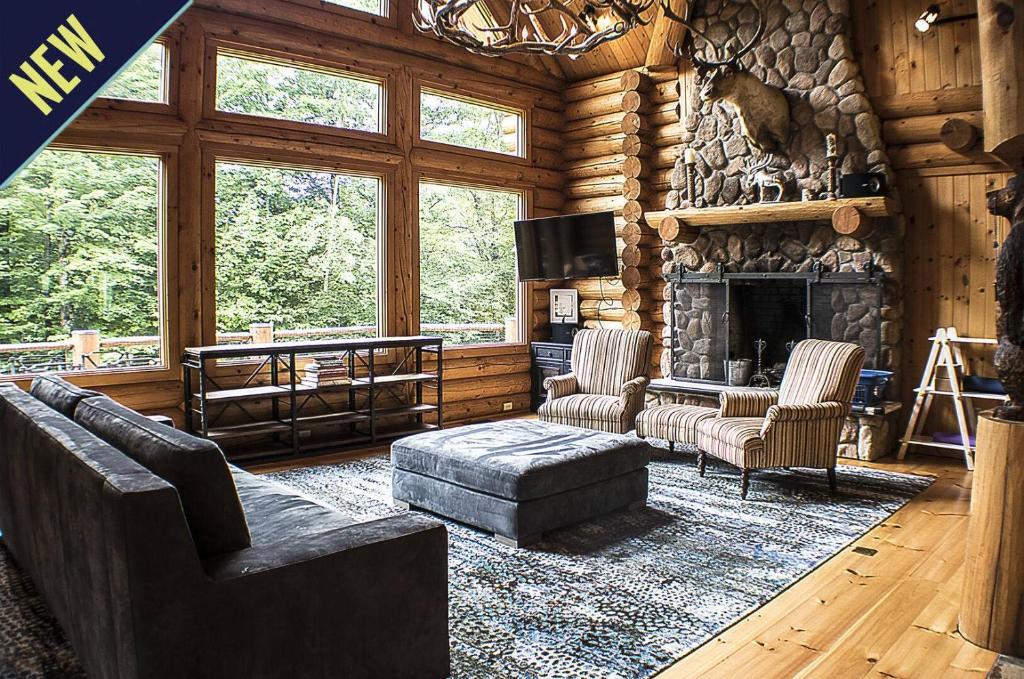 ein Wohnzimmer mit einem Kamin in einer Blockhütte in der Unterkunft Enjoy this stunning Log home with open floor plan and tons of natural lighting Ridgetop in Killington