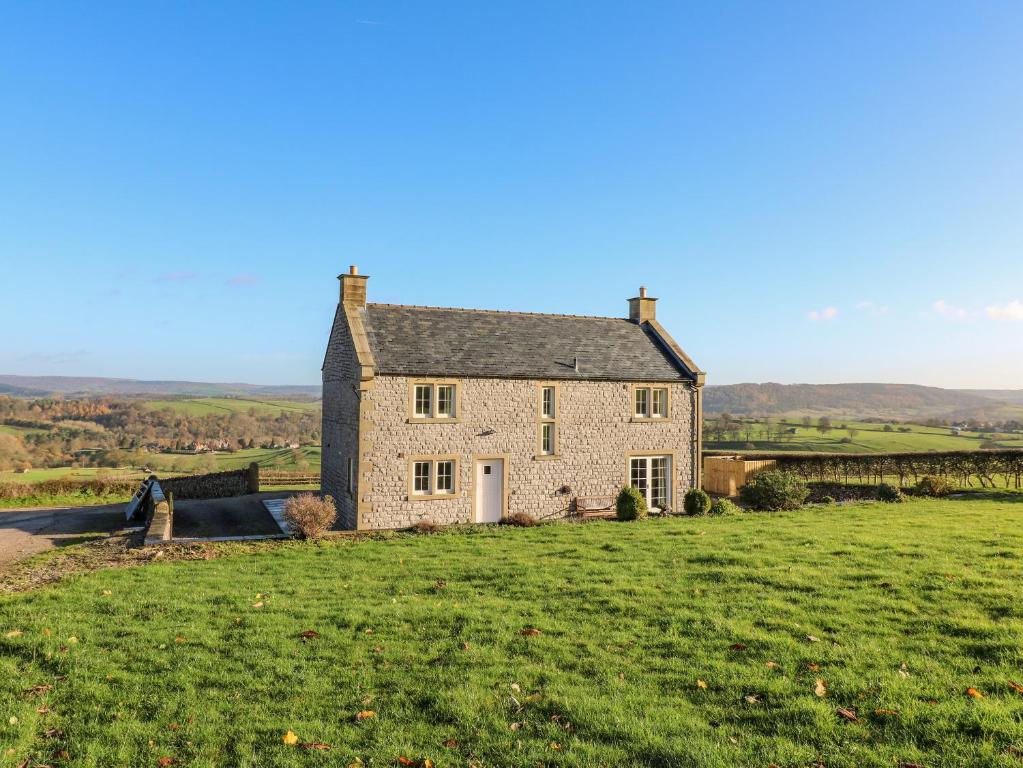 an old stone house in a field of grass at Lower Cowden Farm in Bakewell