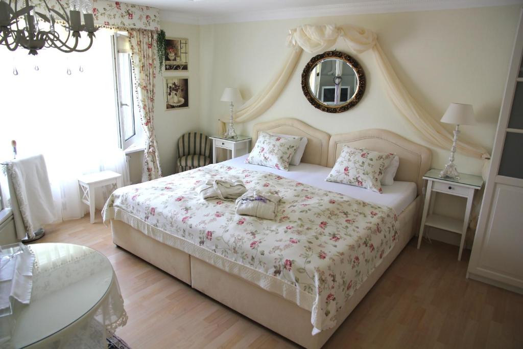 1 dormitorio con cama y espejo en la pared en Bed and Breakfast Im Röseligarten en Wolfhausen