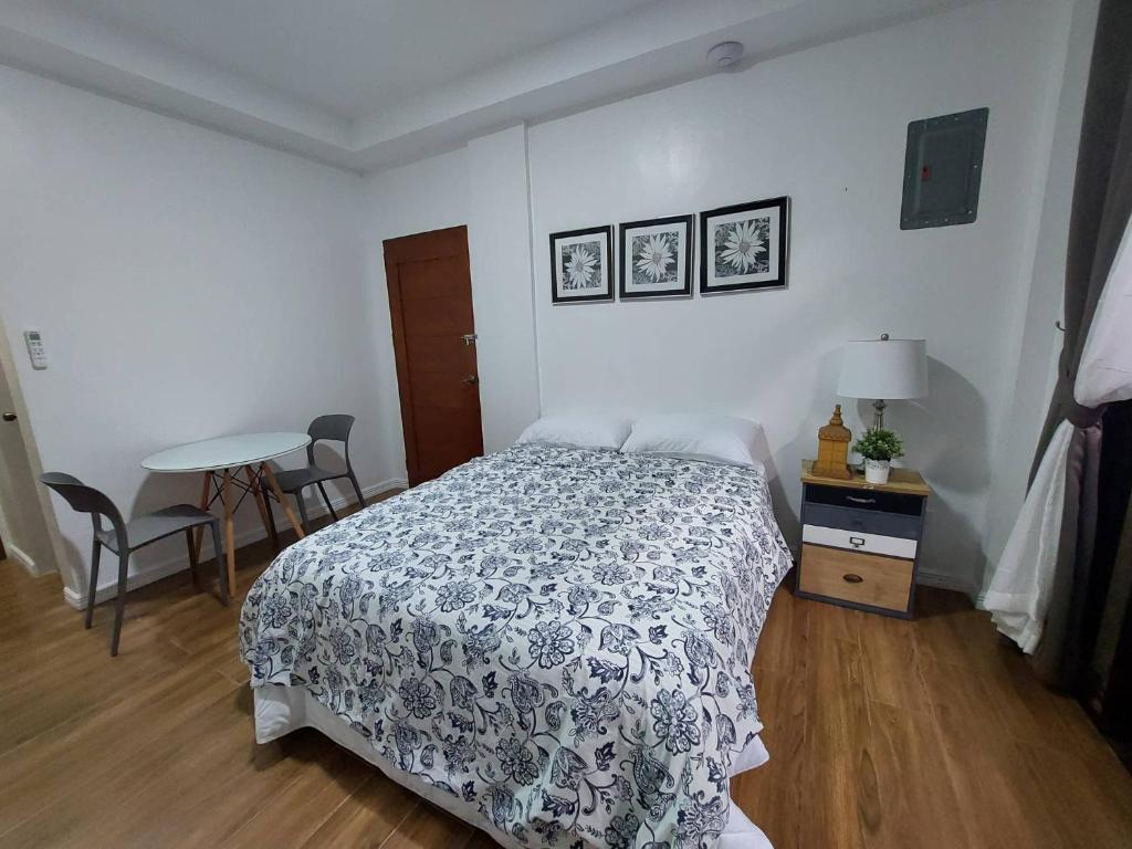 een slaapkamer met een bed en een tafel met stoelen bij Regal425 Condotel in Angeles