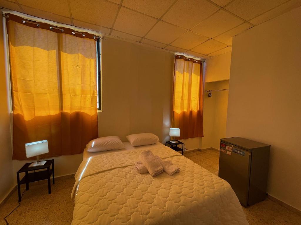 una camera da letto con un letto e un asciugamano sopra di Hotel Colonial Blanco a Santo Domingo