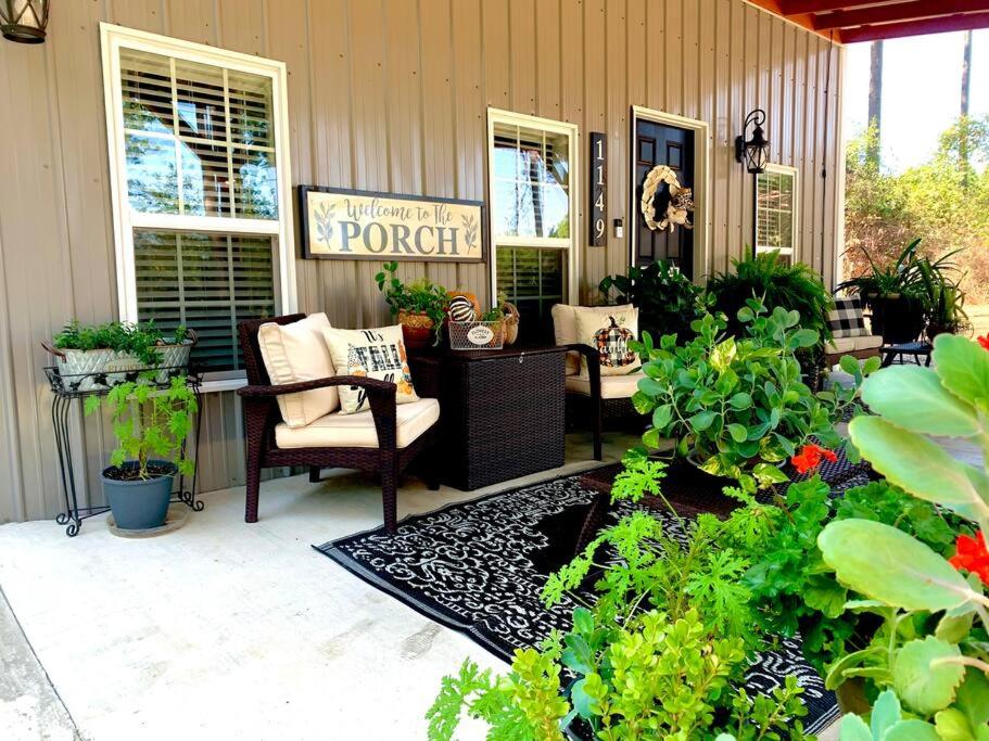 a patio with chairs and plants in front of a house at A Tranquil Retreat Loaded With Ambiance! Sleeps 10 in Platt