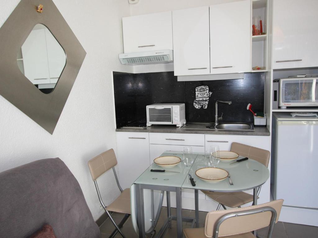 a kitchen with a table with chairs and a microwave at Studio Chamrousse, 1 pièce, 3 personnes - FR-1-340-264 in Chamrousse