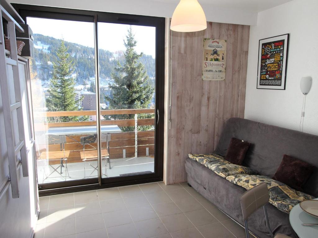 sala de estar con sofá y puerta corredera de cristal en Studio Chamrousse, 1 pièce, 3 personnes - FR-1-340-264, en Chamrousse