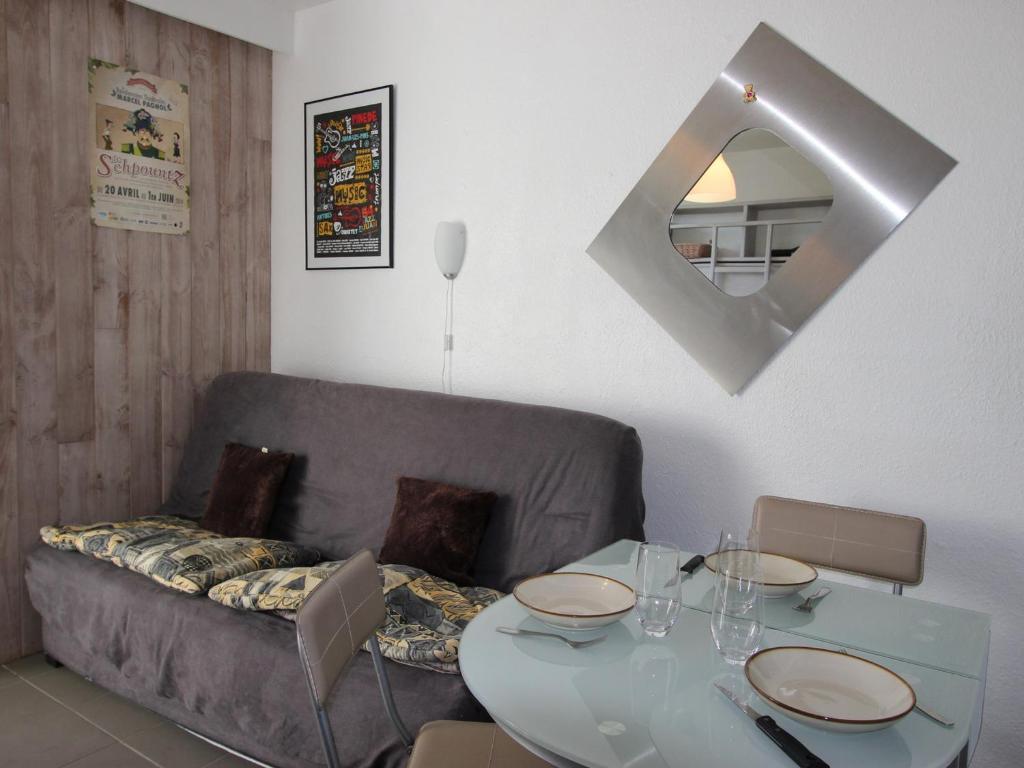 a living room with a couch and a table and a mirror at Studio Chamrousse, 1 pièce, 3 personnes - FR-1-340-264 in Chamrousse