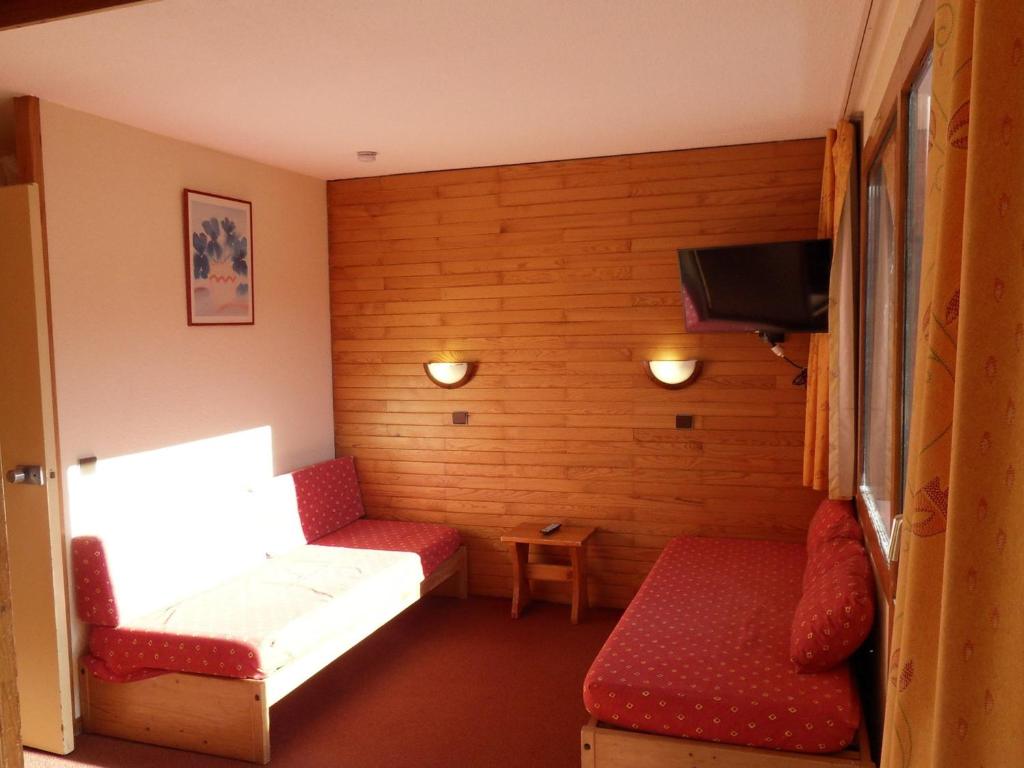 une petite chambre avec deux canapés et une télévision dans l'établissement Studio divisible 4 pers, centre station, balcon sud, proche pistes, animaux admis - FR-1-181-2699, à La Plagne Tarentaise