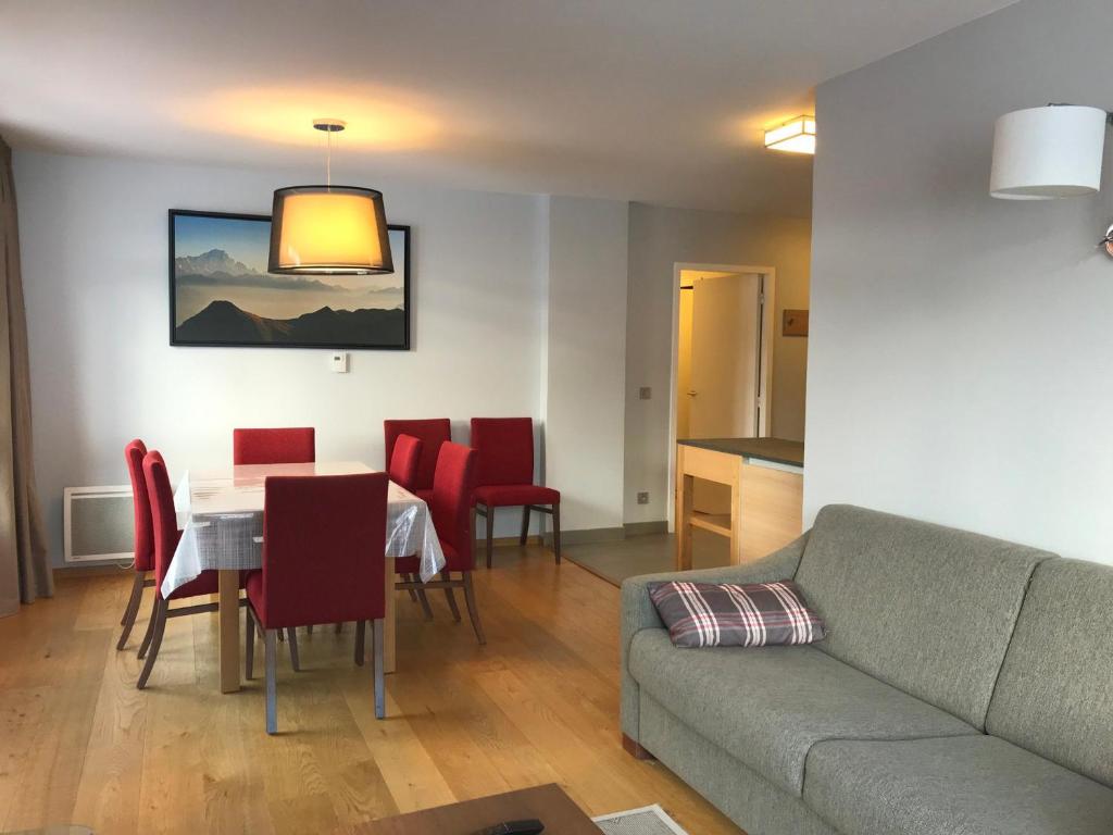 salon z kanapą, stołem i krzesłami w obiekcie Appartement spacieux avec parking, balcon et accès piscine - Front de neige - FR-1-346-536 w mieście Arc 1800