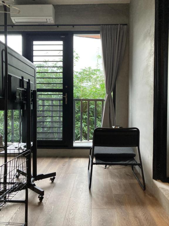 宜蘭市にあるhsueh_houseの椅子、テレビ、バルコニーが備わる客室です。