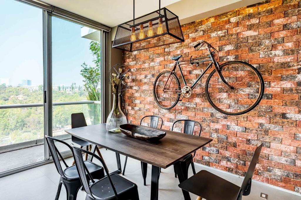 a dining room with a bike hanging on a brick wall at Departamento con las mejores vistas de la ciudad en Condesa - pool - gym - parking - AC in Mexico City