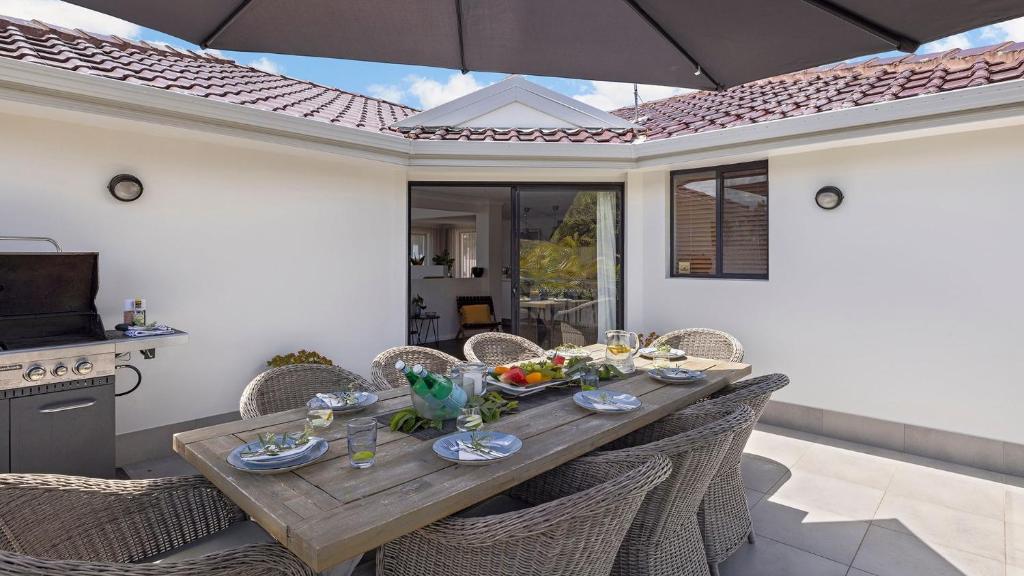 サラマンダー・ベイにあるBaie de Salamandreのダイニングテーブル(椅子、パラソル付)