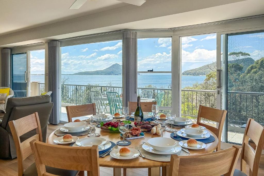 une salle à manger avec une table avec vue sur l'océan dans l'établissement Albacore 7 Waterfront Unit, à Nelson Bay