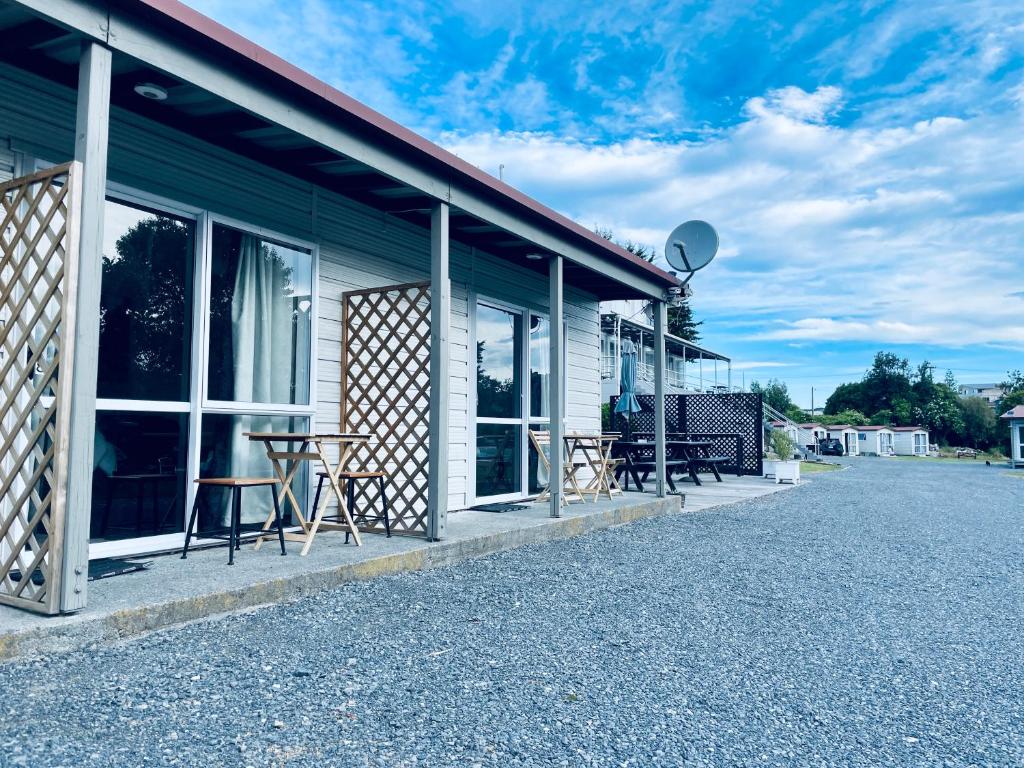 a building with a table and chairs outside of it at A1 Kaikoura Motel & Holiday Park in Kaikoura