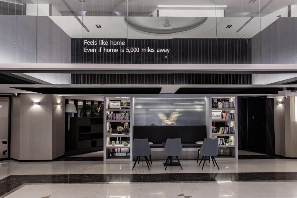 eine Bibliothek mit einem Tisch und Stühlen in einem Gebäude in der Unterkunft Hub Hotel - Songshan Airport Branch in Taipeh