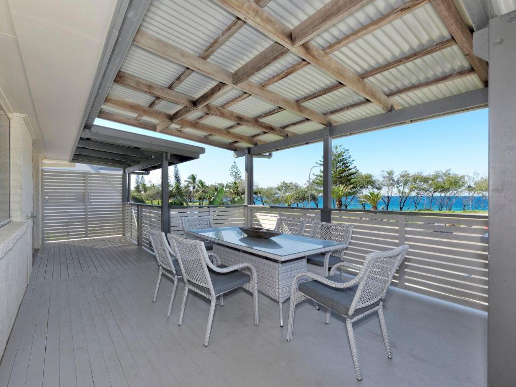 a patio with a table and chairs on a deck at 242 Woongarra Scenic Drive in Bargara