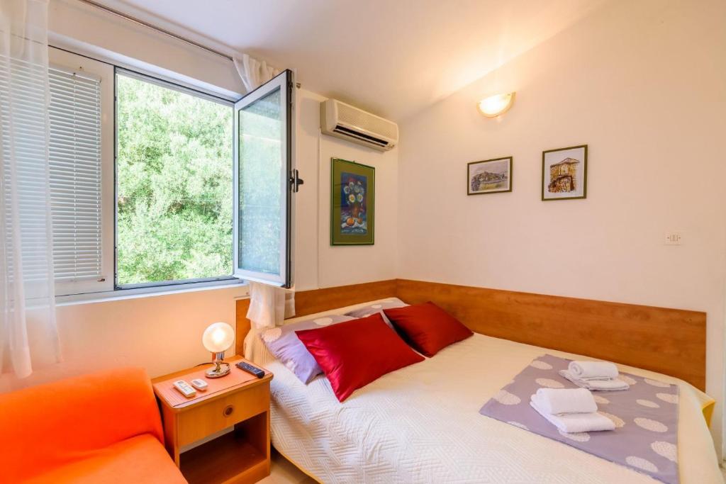 a small bedroom with a bed and a window at Apartments Goge - 90m from beach in Gradac