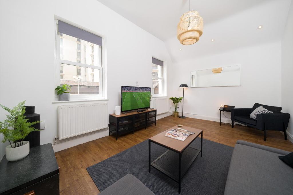a living room with a couch and a tv at Your Own House, 2 Bedr, 3 Beds, 2,5 Bath, Covent Gdn in London