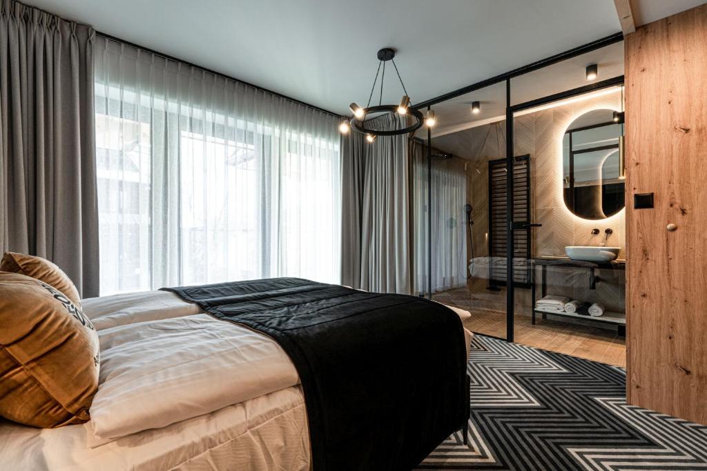 a bedroom with a large bed and a mirror at Aparthotel Zakopane in Zakopane