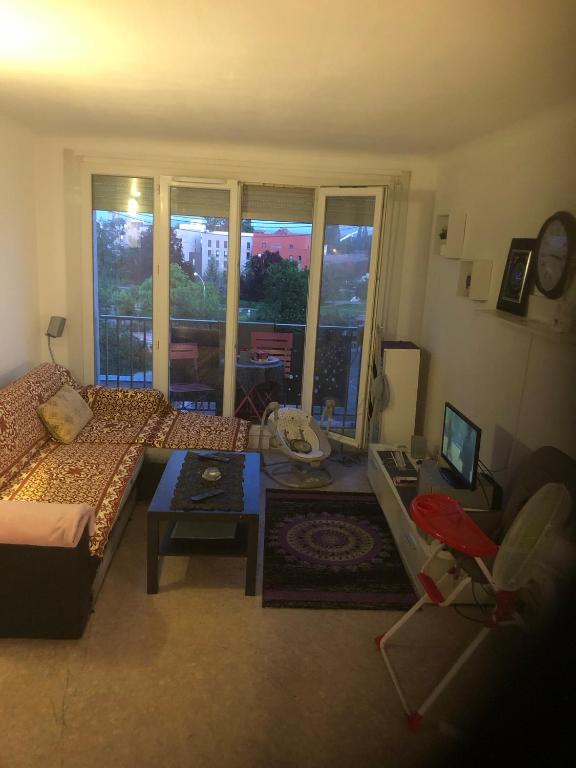 a living room with a couch and a table at Appartement chaleureux et calme in Strasbourg