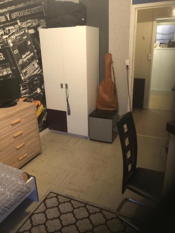 a bedroom with a desk and a dresser and a guitar at Appartement chaleureux et calme in Strasbourg