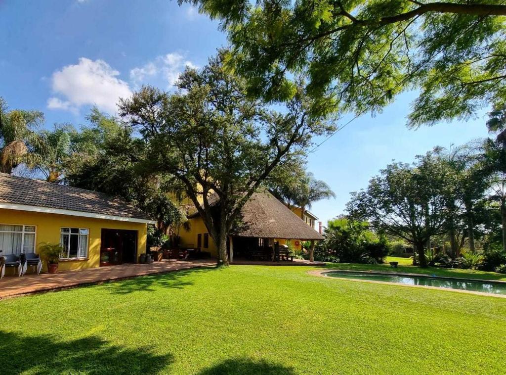 a house with a yard with a tree and a pool at Pecan Nut Place in Dalmada