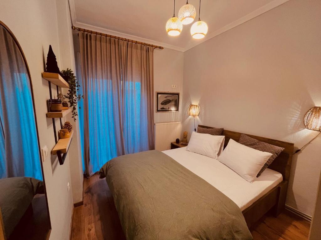 um quarto com uma cama grande e cortinas azuis em Evenos em Kavala