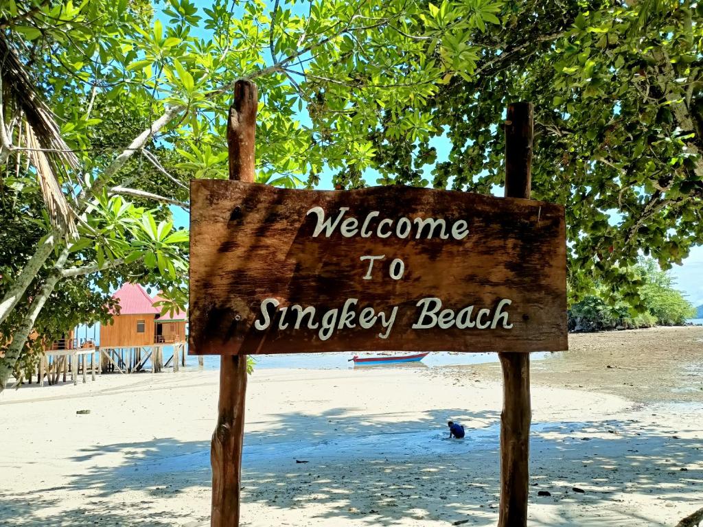 um sinal que diz bem-vindo à praia em Sing Key Beach em Masohi