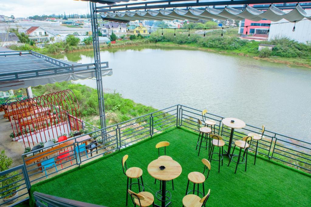 a balcony with a table and chairs and a body of water at Trung Nghĩa Villa 21 in Da Lat